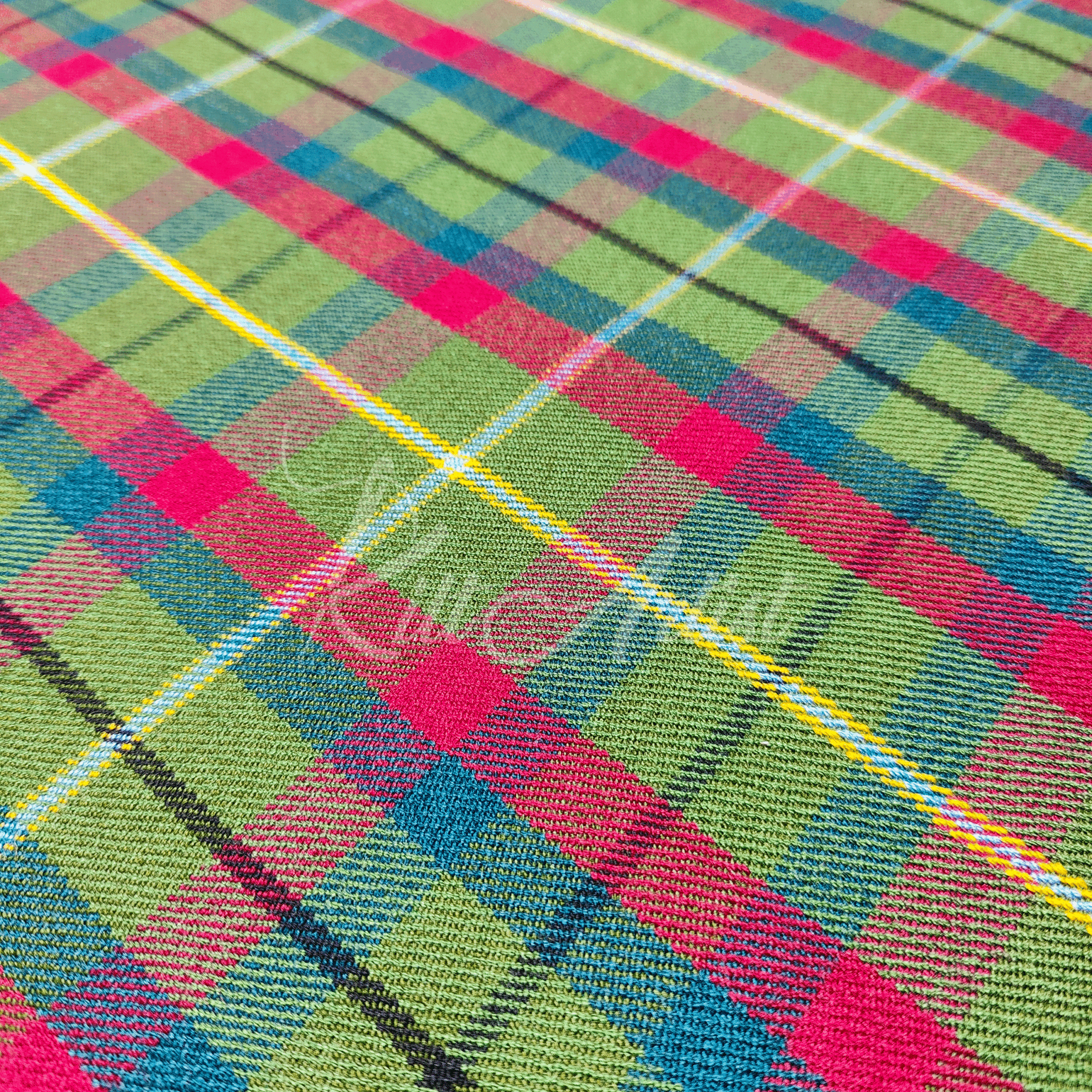 Close-up of a green tartan fabric featuring a diagonal pattern of lime green and magenta squares with white, yellow, and blue accent lines.