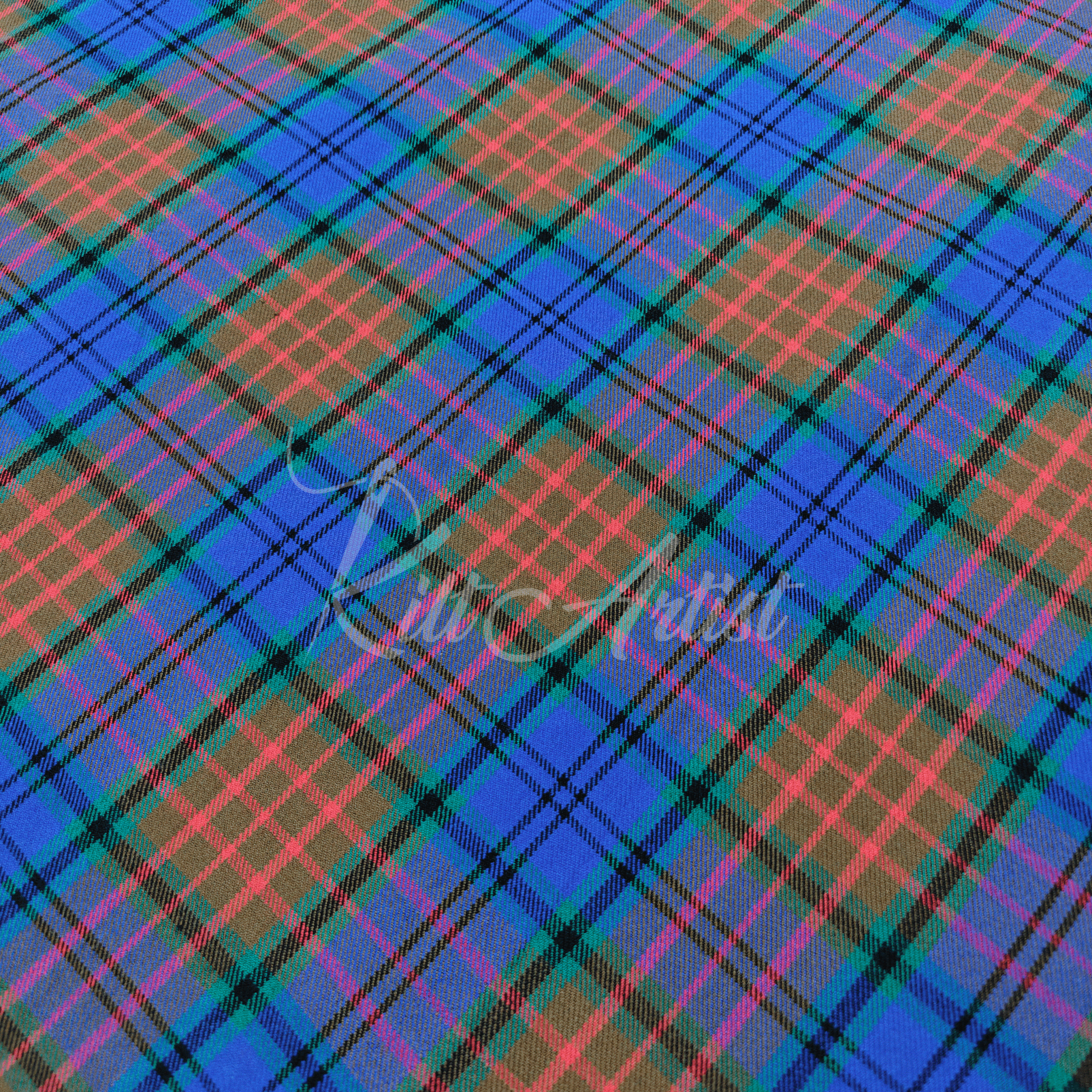 A hand holding a fold of Scottish Rivers tartan fabric featuring a vibrant mix of royal blue, earthy brown, and forest green with coral and black accent stripes.